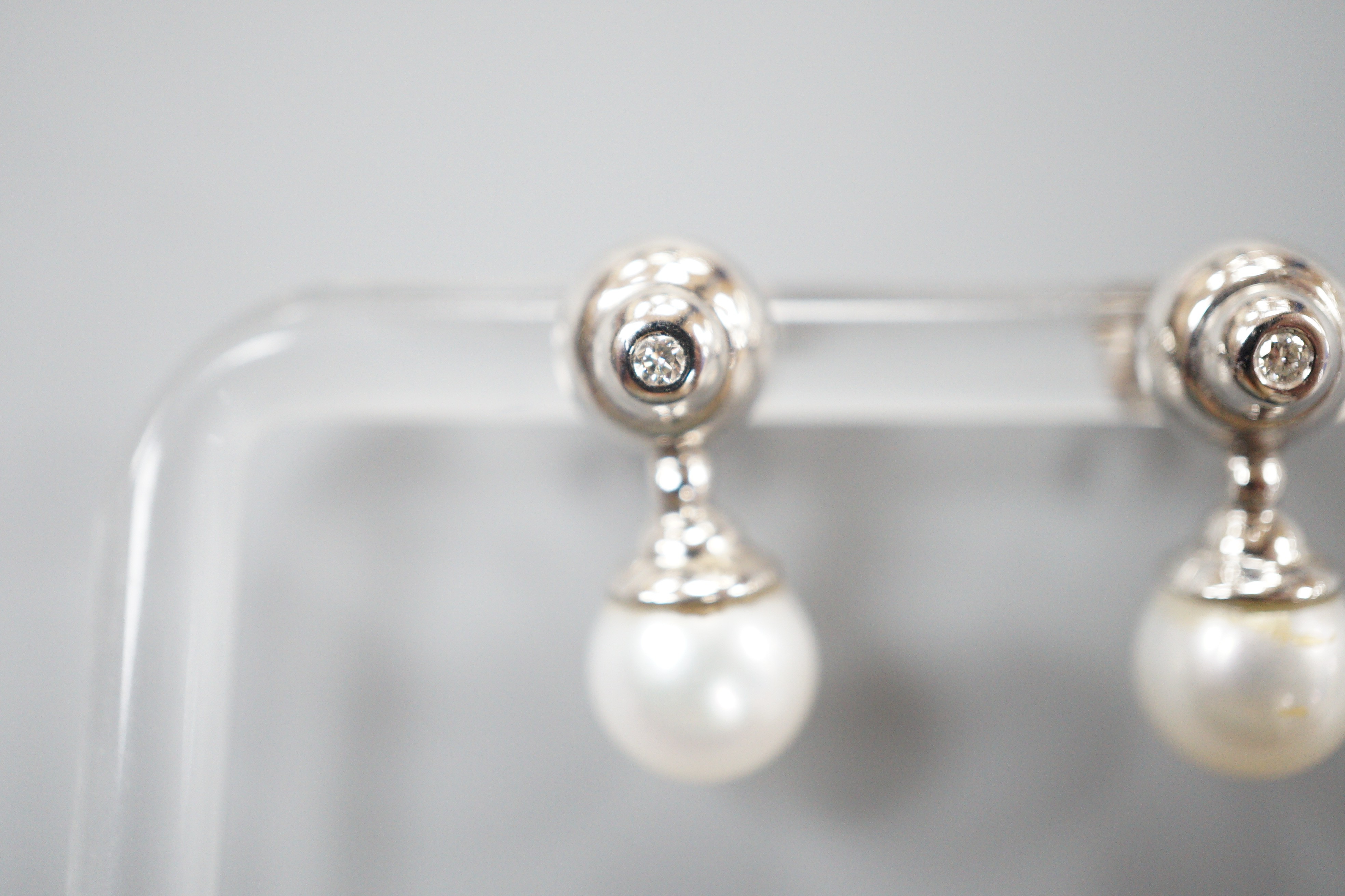 A modern pair of 198ct white gold cultured pearl and single stone collet set diamond ear studs, 19mm, gross weight 5.4 grams.